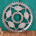 Kettenblatt, Ende 20er/30er J., 1/2 Zoll, verchromt, umlaufendes Radfahrermotiv, 48 Zähne, gebr. 